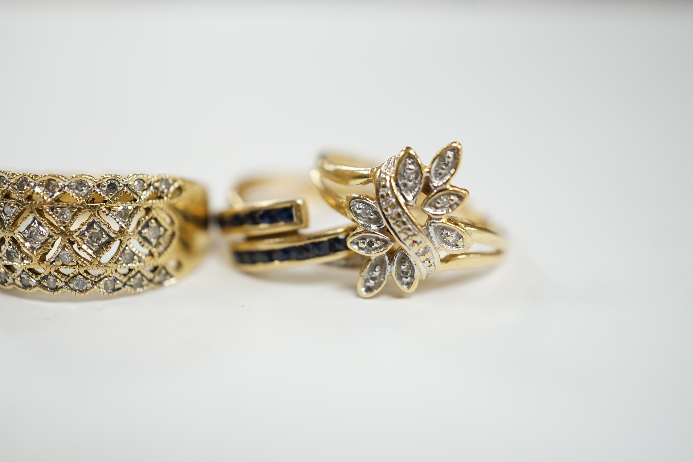 Three assorted modern 18k and gem set rings, including two diamond chip clusters, gross weight 8.2 grams
